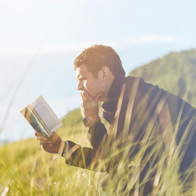 Man reading book outdoors