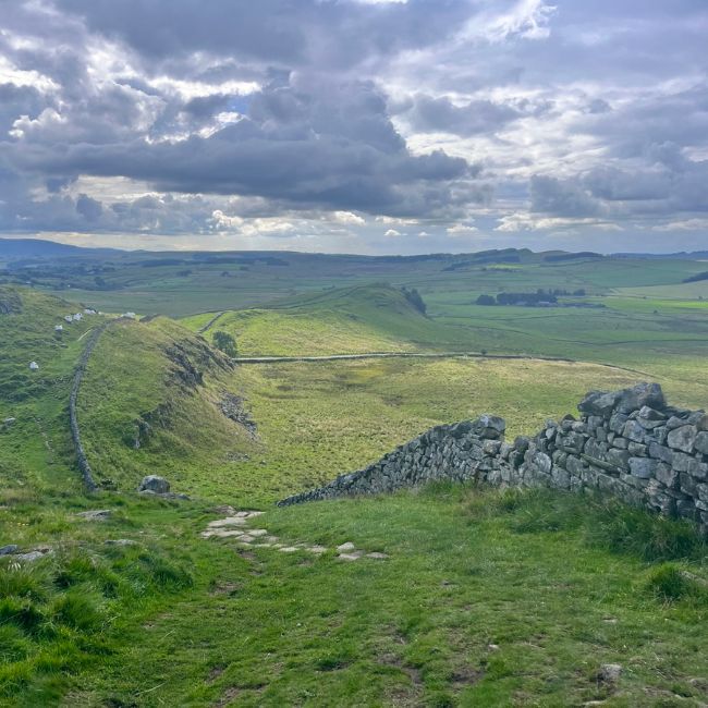 View of Hadrian's Wall and hills on a cloudy day.