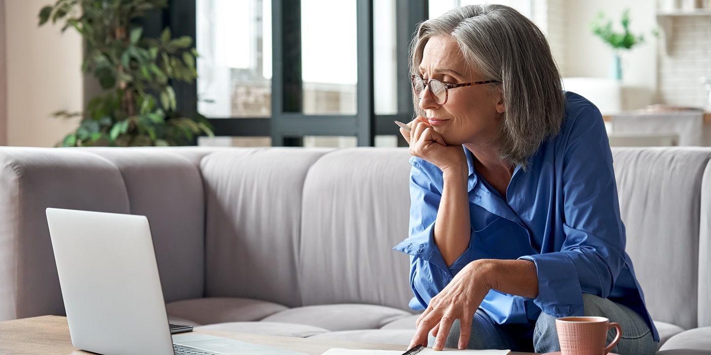 Lady looking at laptop making notes