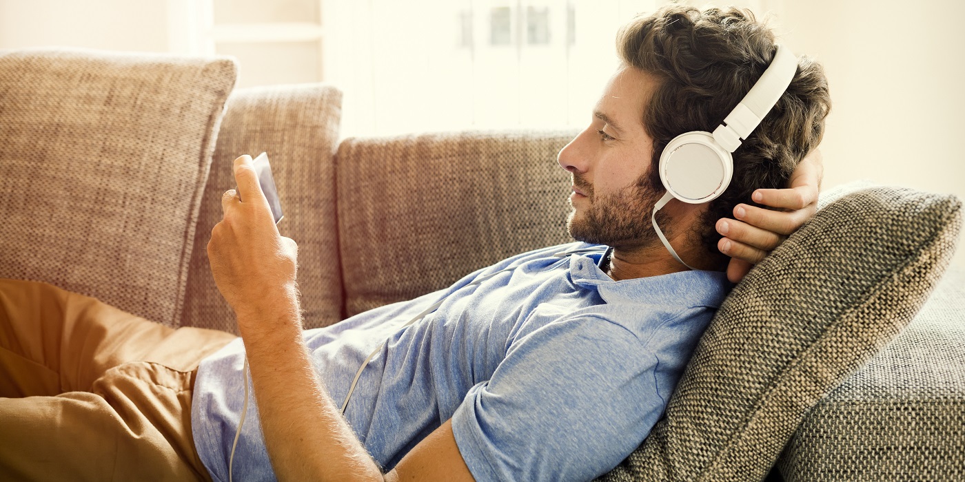 Man on sofa with headphones