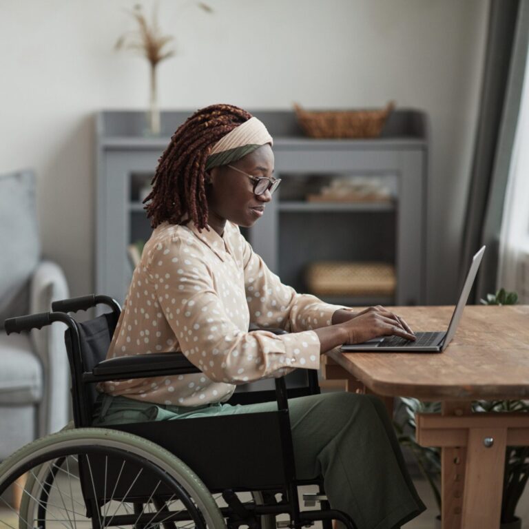 Black woman in wheelchair using a laptop